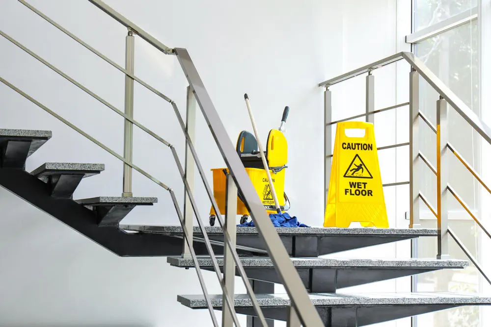 Fußboden und Eimer mit Mopp auf Treppen. Reinigungsdienst